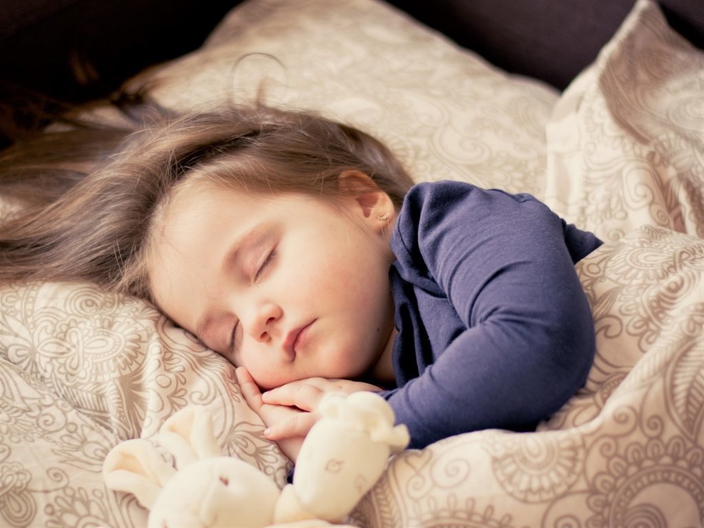 Little Girl Sleeping with a stuffed bunny.