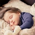 Little Girl Sleeping with a stuffed bunny.